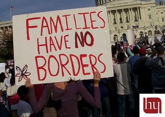 A protester holding a sign. Immigration Reform vs. Immigration Reality.