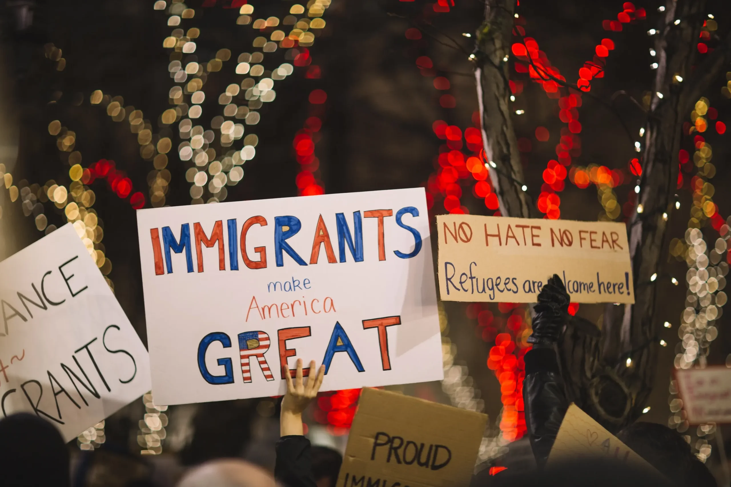 Protesters holding signs celebrating immigrants - Why We Love Immigrants (and You Should, Too!)