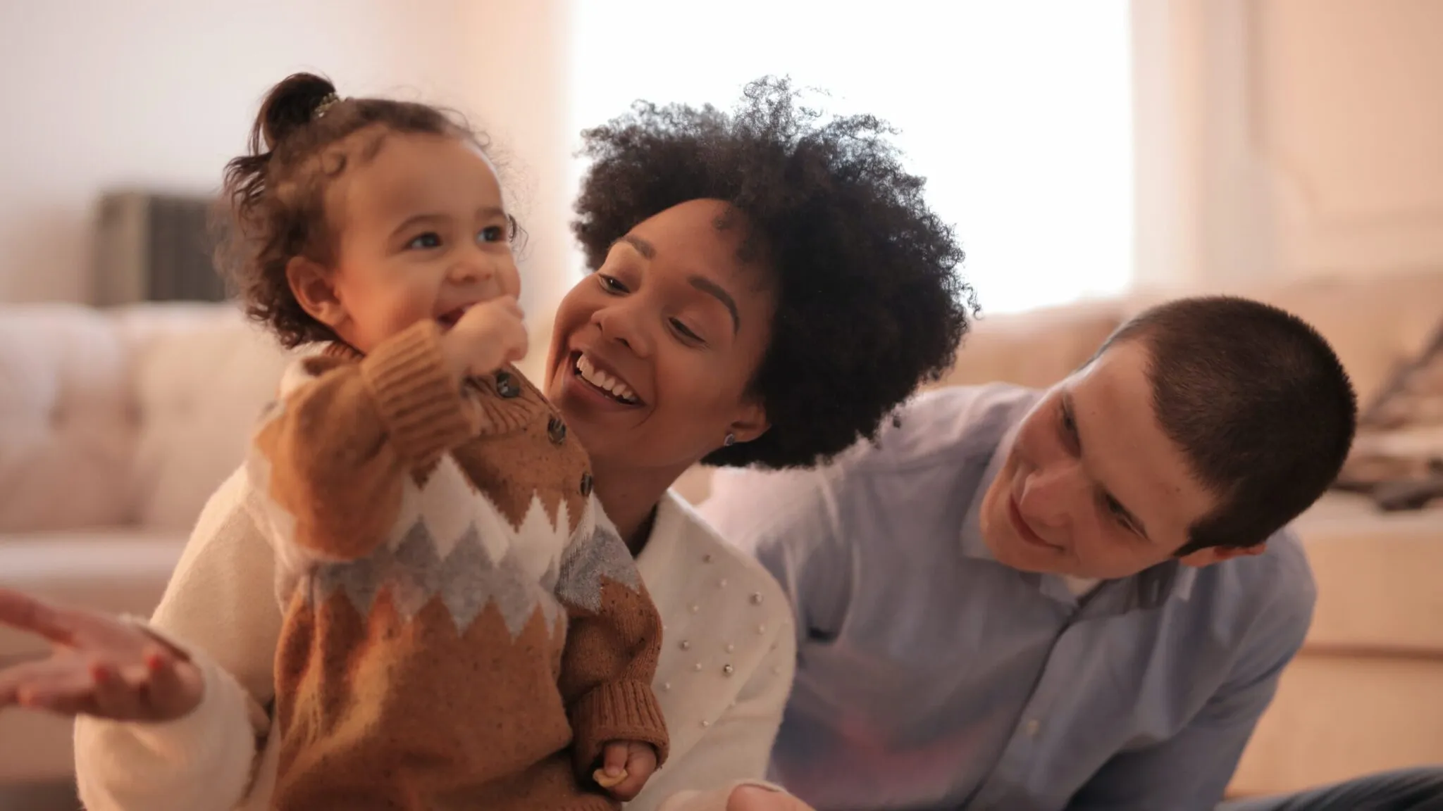 A happy immigrant family holding their child. Planning their child's future and how to avoid the worst mistakes in the US naturalization process.